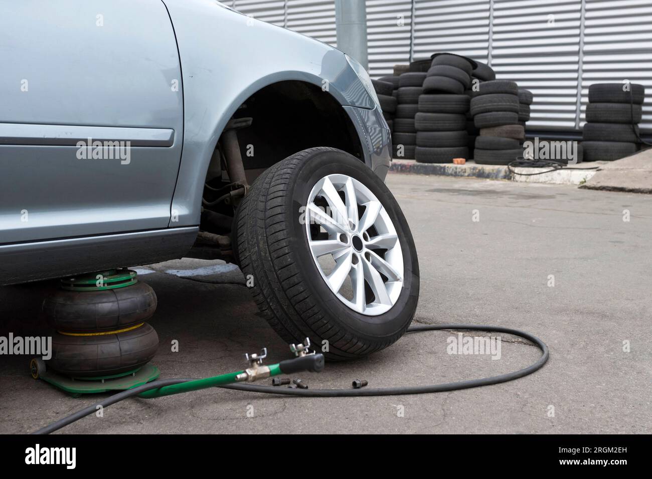 La voiture est à un service de voiture. En remplaçant les roues de la voiture, le cric maintient la carrosserie en position relevée Banque D'Images
