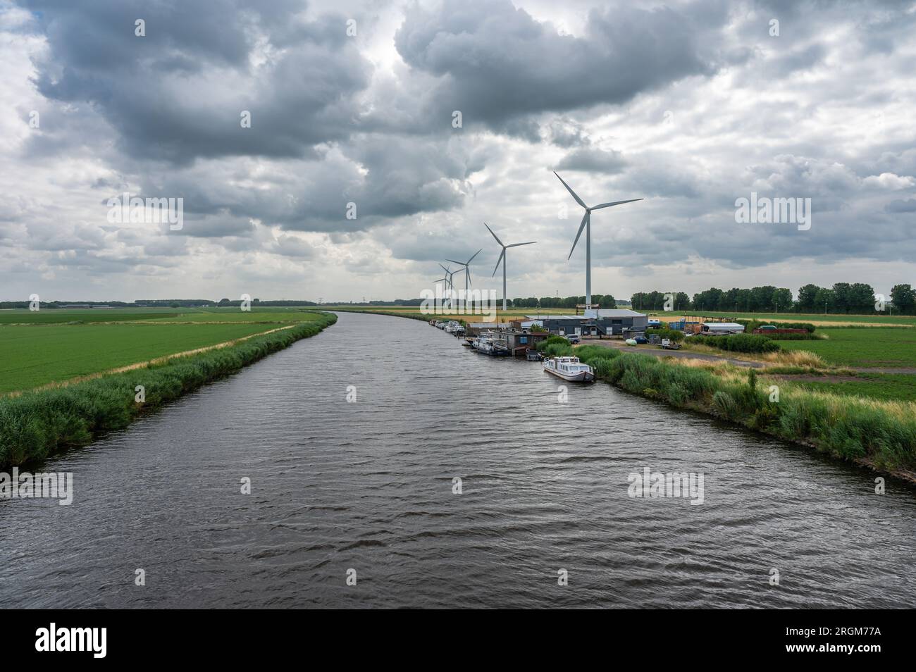 Fijnaart, Brabant du Nord, pays-Bas, juillet 03 2023 - énergie éolienne et industrie au bord de la rivière Dintel Banque D'Images