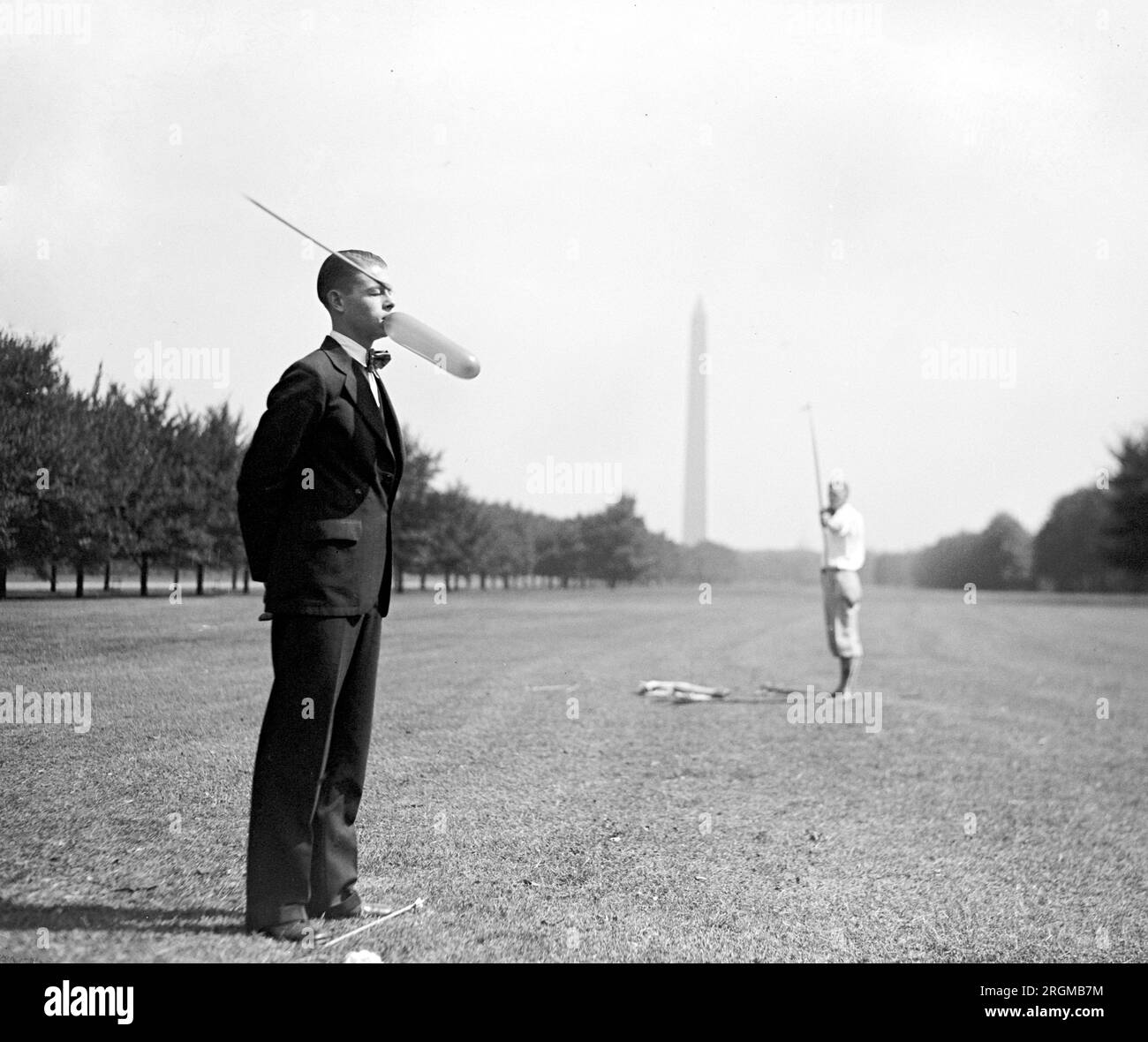 Tir à l'arc vintage : Russell Hoogerhyde, Clyde Wentworth, homme tirant une flèche sur un ballon ca. 1929 Banque D'Images