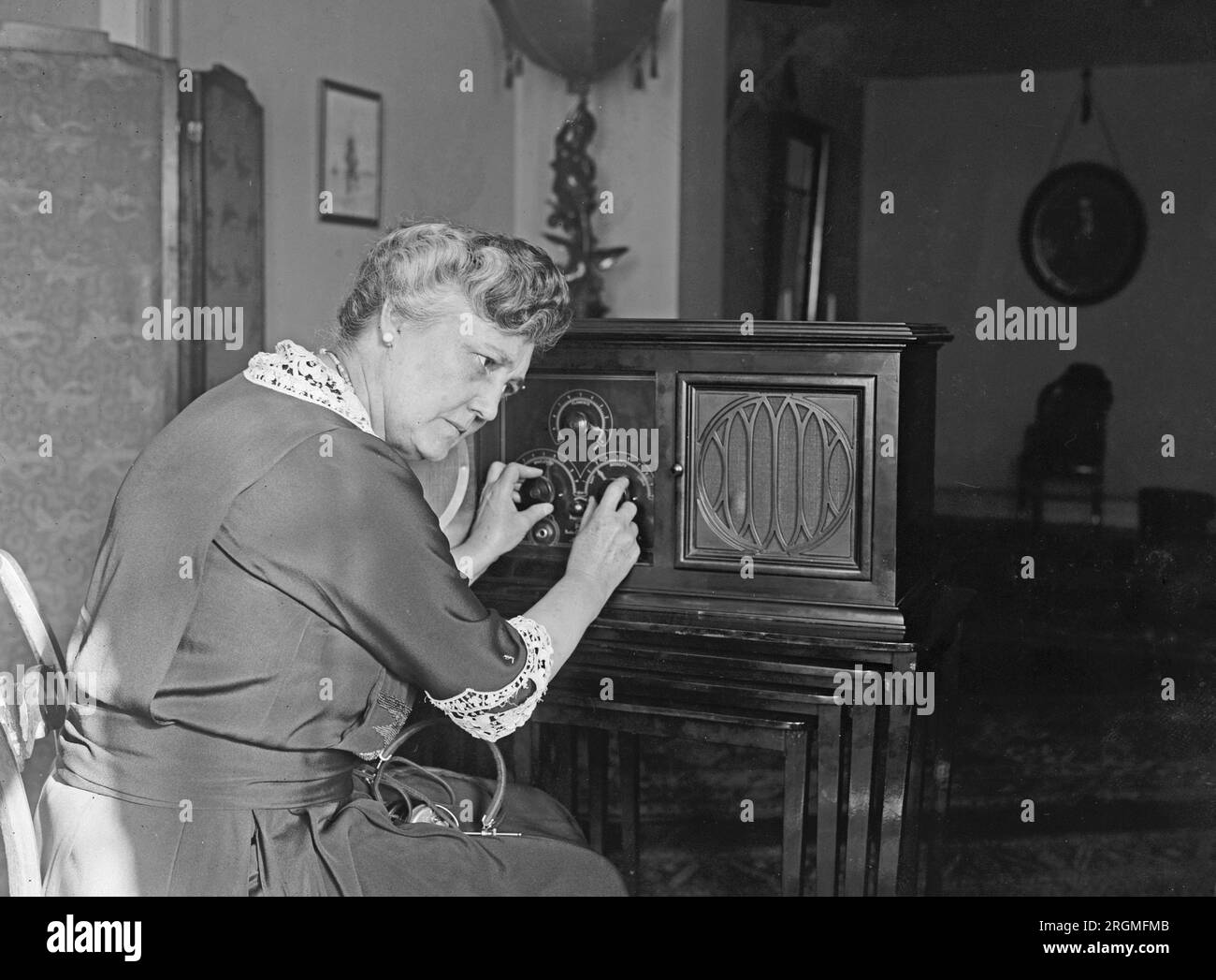 Femme tournant les cadrans sur une radio ca. 1923 Banque D'Images