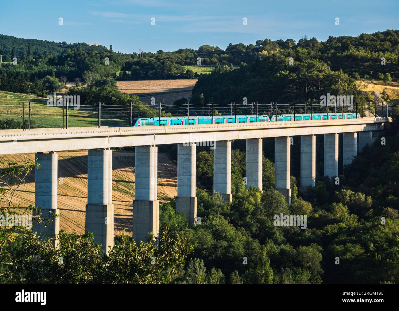 Grane, France - 4 août 2023 : vue panoramique sur un train de voyageurs TGV traversant l'envol ferroviaire. Vue sur les montagnes environnantes en France Banque D'Images