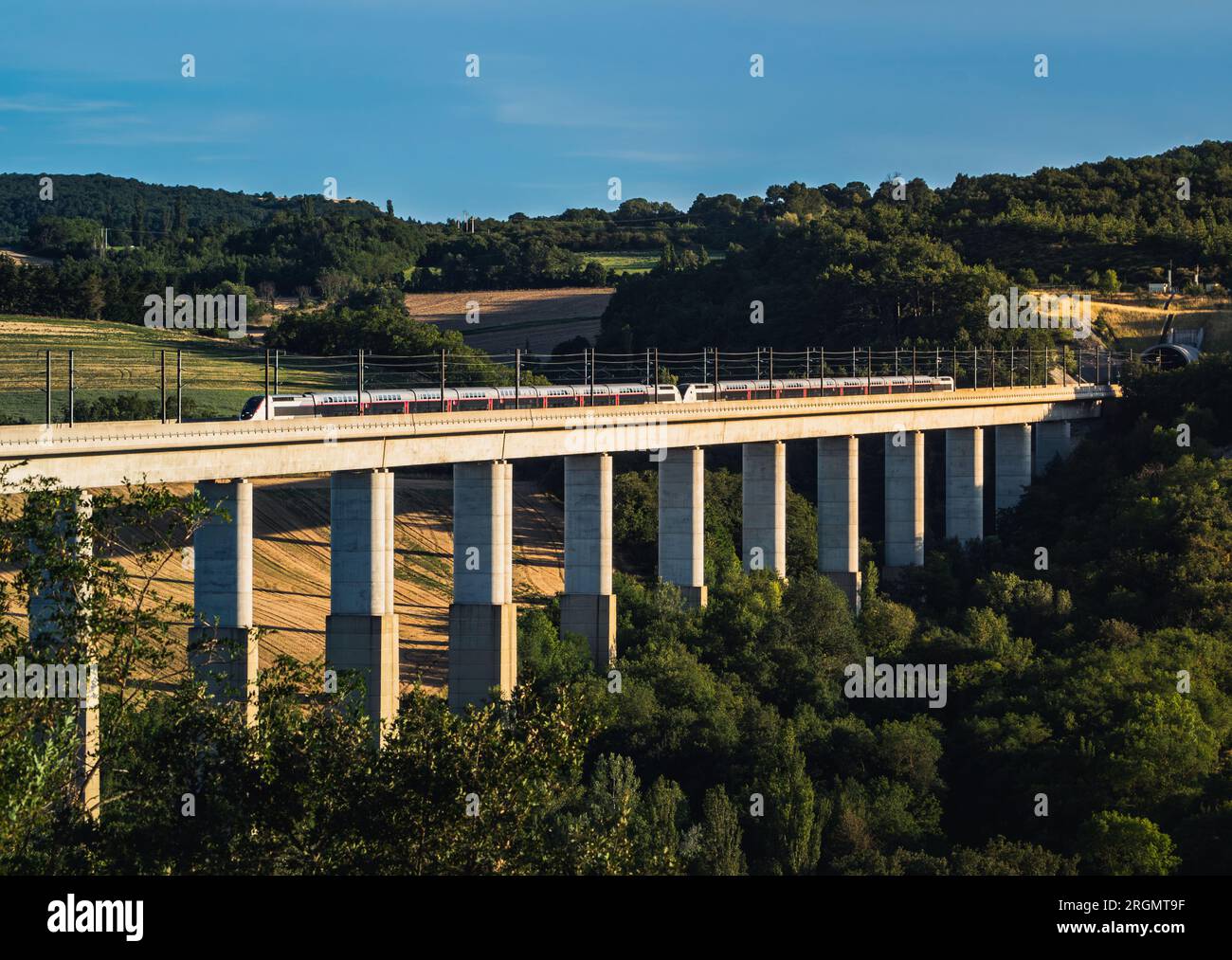 Grane, France - 4 août 2023 : vue panoramique sur un train de voyageurs TGV traversant l'envol ferroviaire. Vue sur les montagnes environnantes en France Banque D'Images