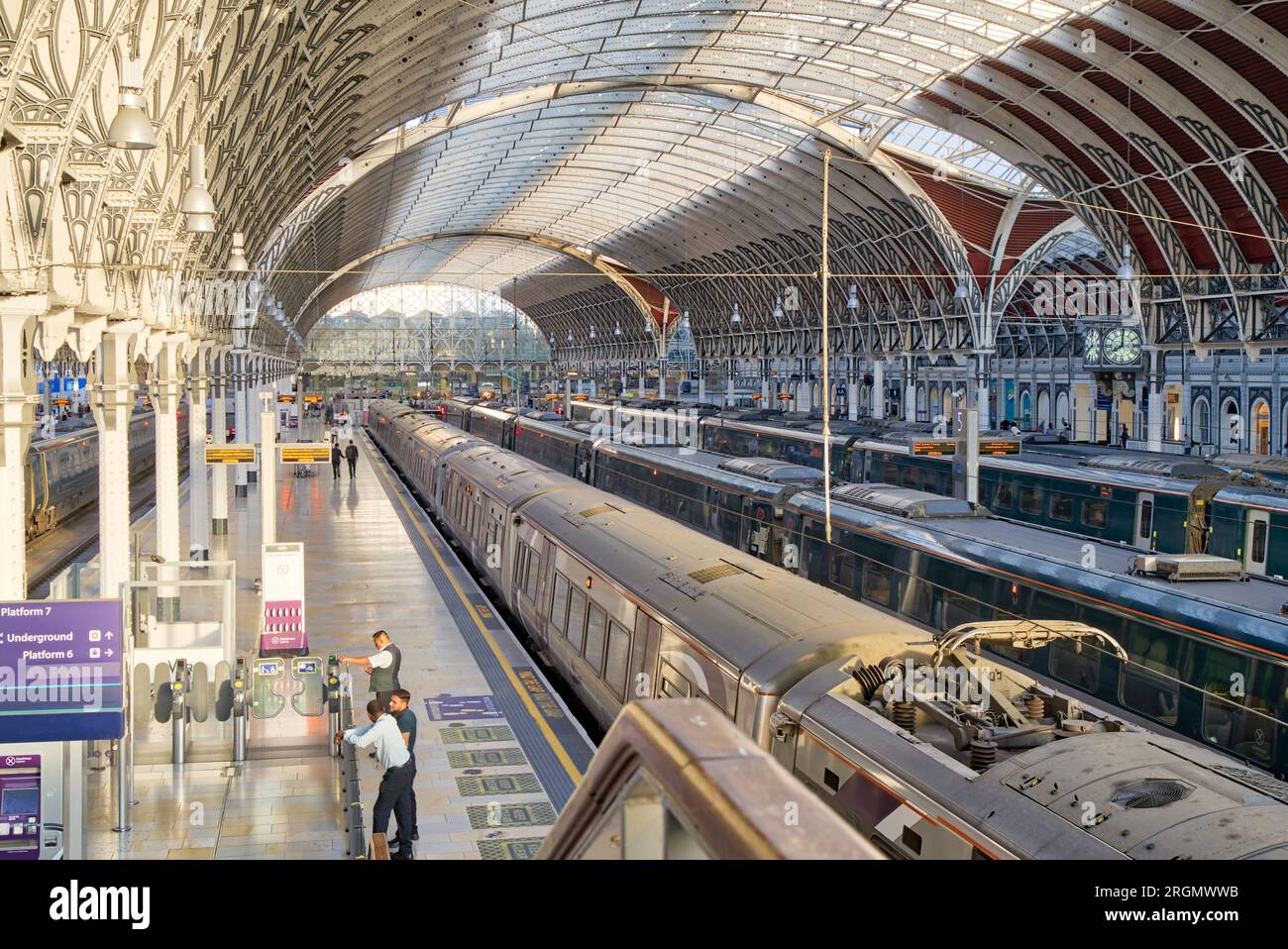 Le soir, le soleil rayonne à travers des lunettes de toit en voûte sur le quai de la gare de Paddington, le train GWR attend les passagers du soir London UK Banque D'Images