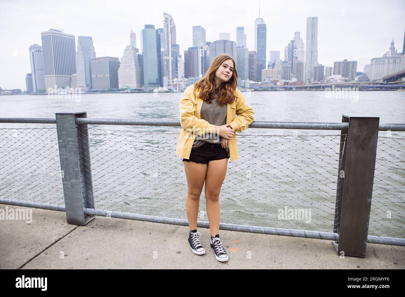 Jeune fille de 16 ans posant près de l'East River avec Manhattan en arrière-plan Banque D'Images