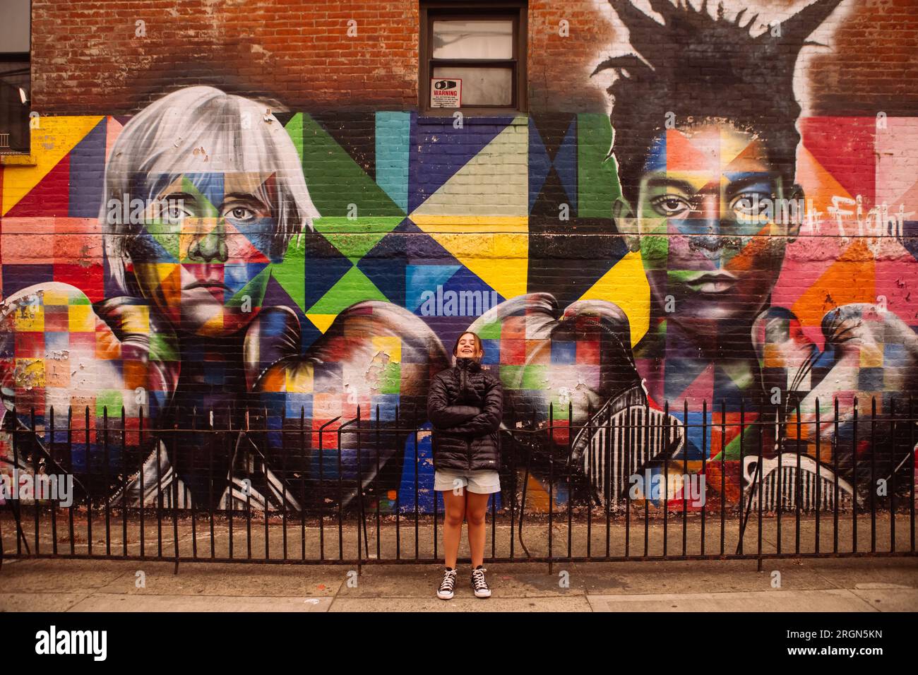 Jeune fille debout devant Kobra graffiti d'Andy Warhol et Basquiat dans les murs de Williamsburg, Brooklyn, New York, USA Banque D'Images
