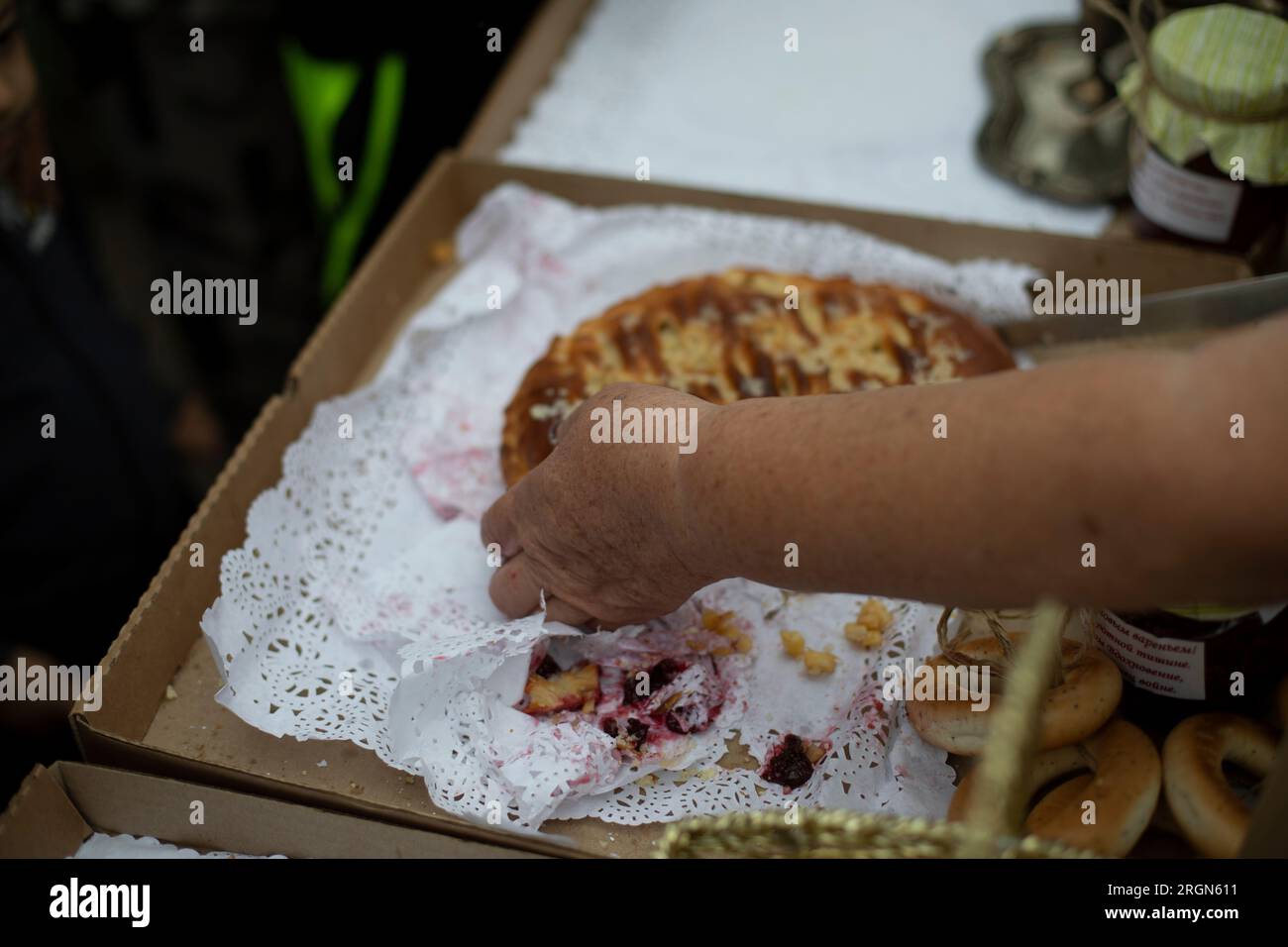 Coupe la tarte à la main. Bonbons russes. Pâtisseries de grand-mère. Nourriture délicieuse. Détails du produit à base de farine. Couteau dans la main du cuisinier. Banque D'Images