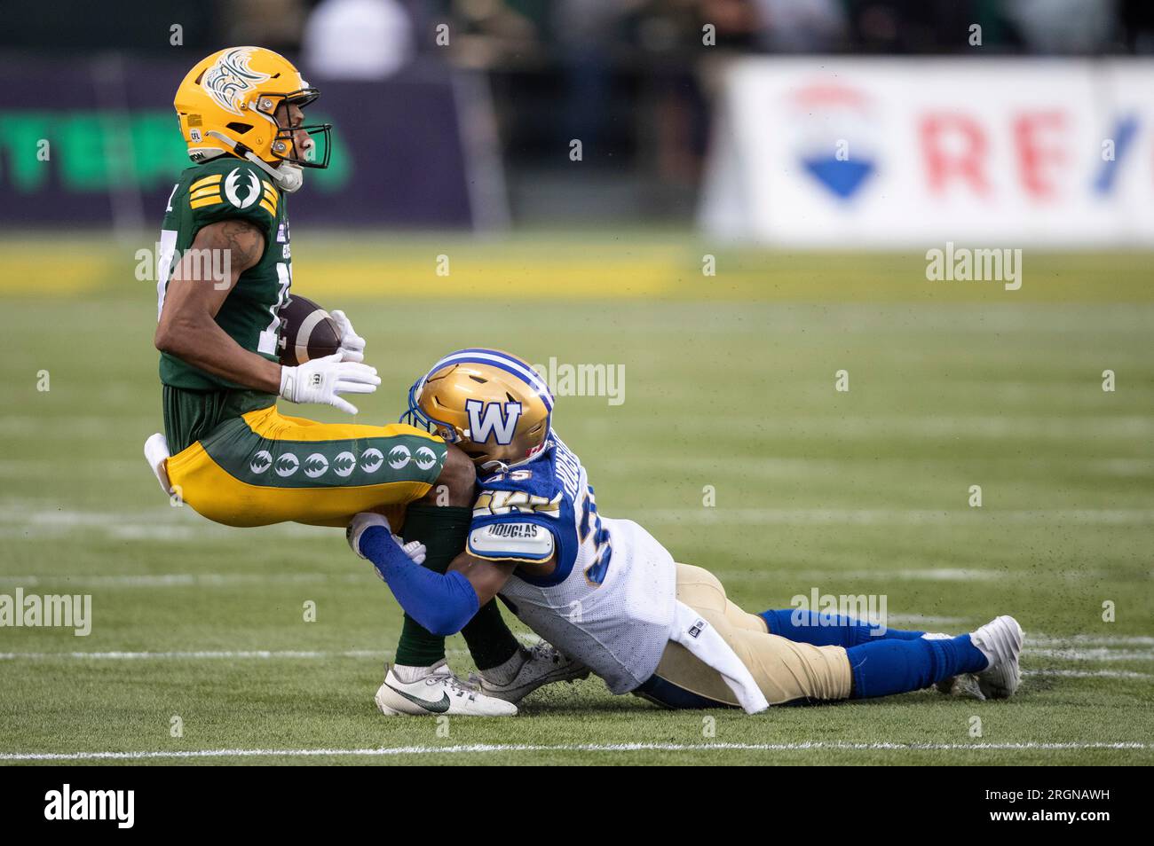 Winnipeg Blue Bombers' Demerio Houston (35) tackles Edmonton Elks' Dillon Mitchell (17) during the first half of a Canadian Football League game in Edmonton, Alberta, on Thursday, Aug. 10, 2023.(Jason Franson./The Canadian Press via AP) Banque D'Images