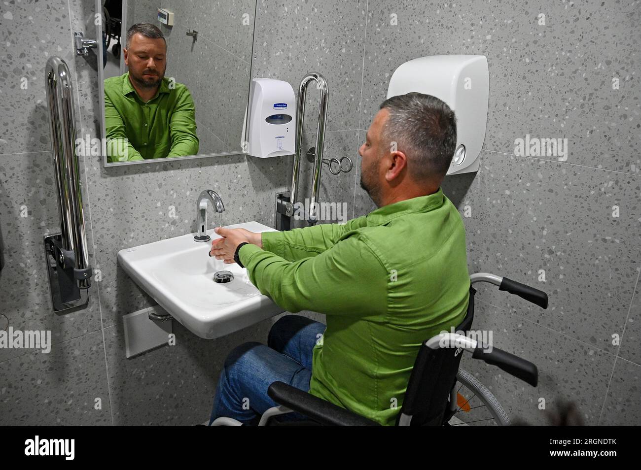 Non exclusive : LVIV, UKRAINE - 9 AOÛT 2023 - un entrepreneur se lave les mains dans des toilettes accessibles pendant que des hommes d'affaires contournent les surhumains Banque D'Images