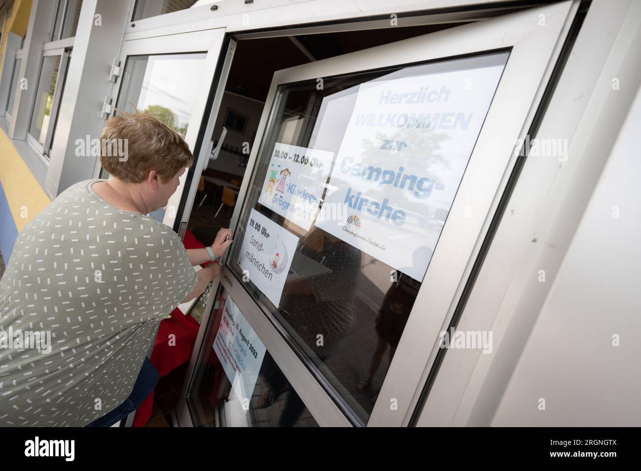 St. Leon Rot, Allemagne. 08 août 2023. L’éducatrice communautaire Daniela Stähle ouvre une porte vers une chambre dans un camping sur Lake St. Leon où les offres d'église de camping ont lieu. L'église protestante du Bade-Württemberg organise douze églises de camping dans l'État. Ils profitent du temps libre des gens en vacances pour éveiller leur intérêt pour la foi et engager une conversation avec eux à ce sujet. Crédit : Marijan Murat/dpa/Alamy Live News Banque D'Images