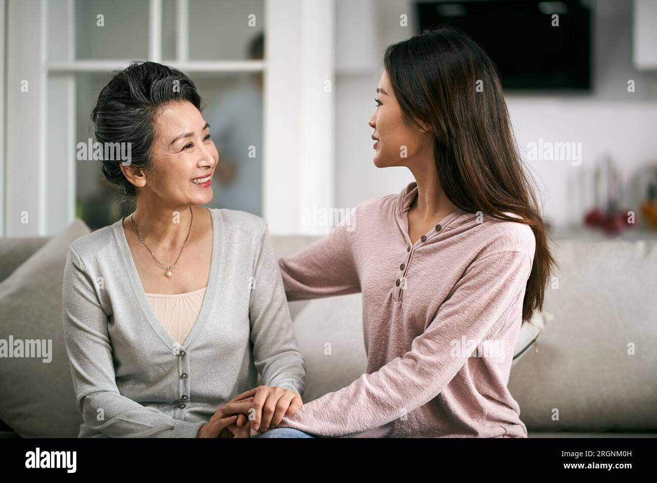 fille adulte asiatique assise sur le canapé à la maison discutant avec la mère âgée heureuse et souriante Banque D'Images
