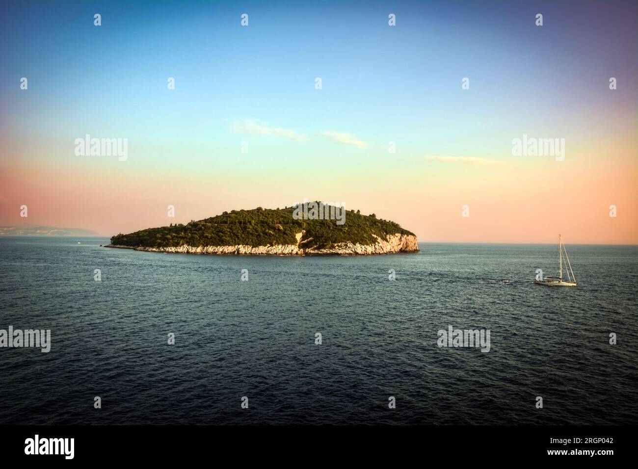 Un voilier solitaire passant par l'île de Lokrum - magnifique coucher de soleil à Dubrovnik, Croatie Banque D'Images