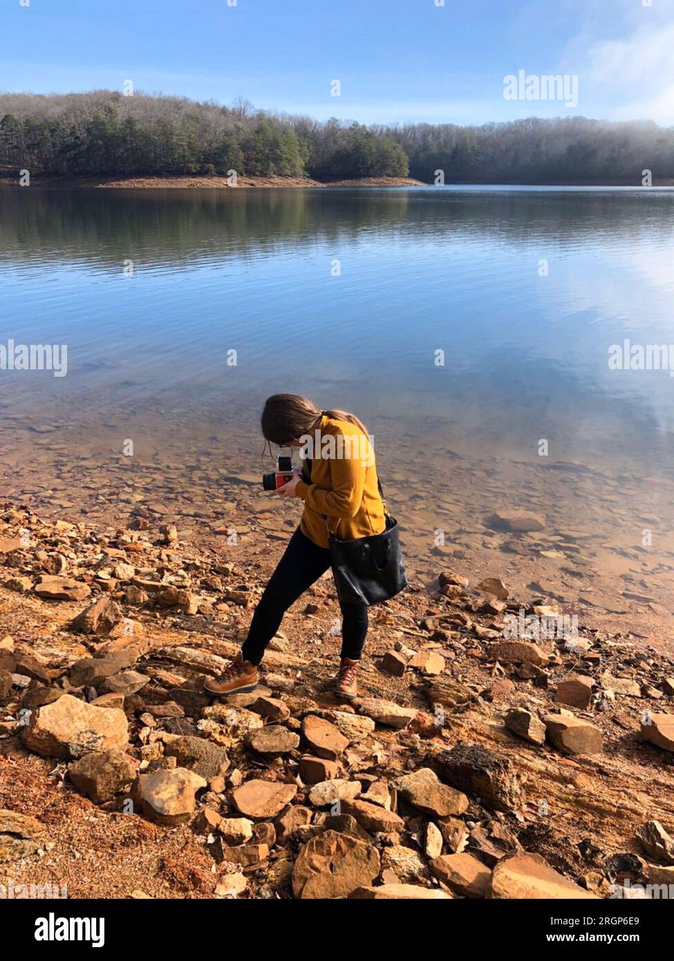 Les photographies de femme tombent sur le lac avec son appareil photo à film moyen format Banque D'Images