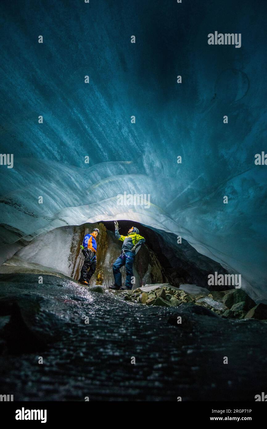 Deux chercheurs étudient un glacier en fonte d'en bas dans une grotte de glace Banque D'Images