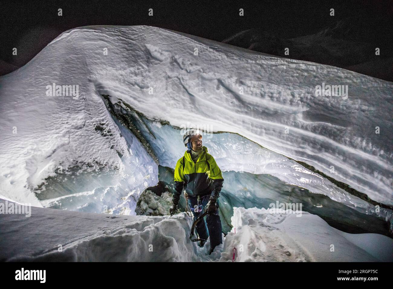 Explorer grimpe hors de la grotte de glace glaciaire, Colombie-Britannique Canada Banque D'Images