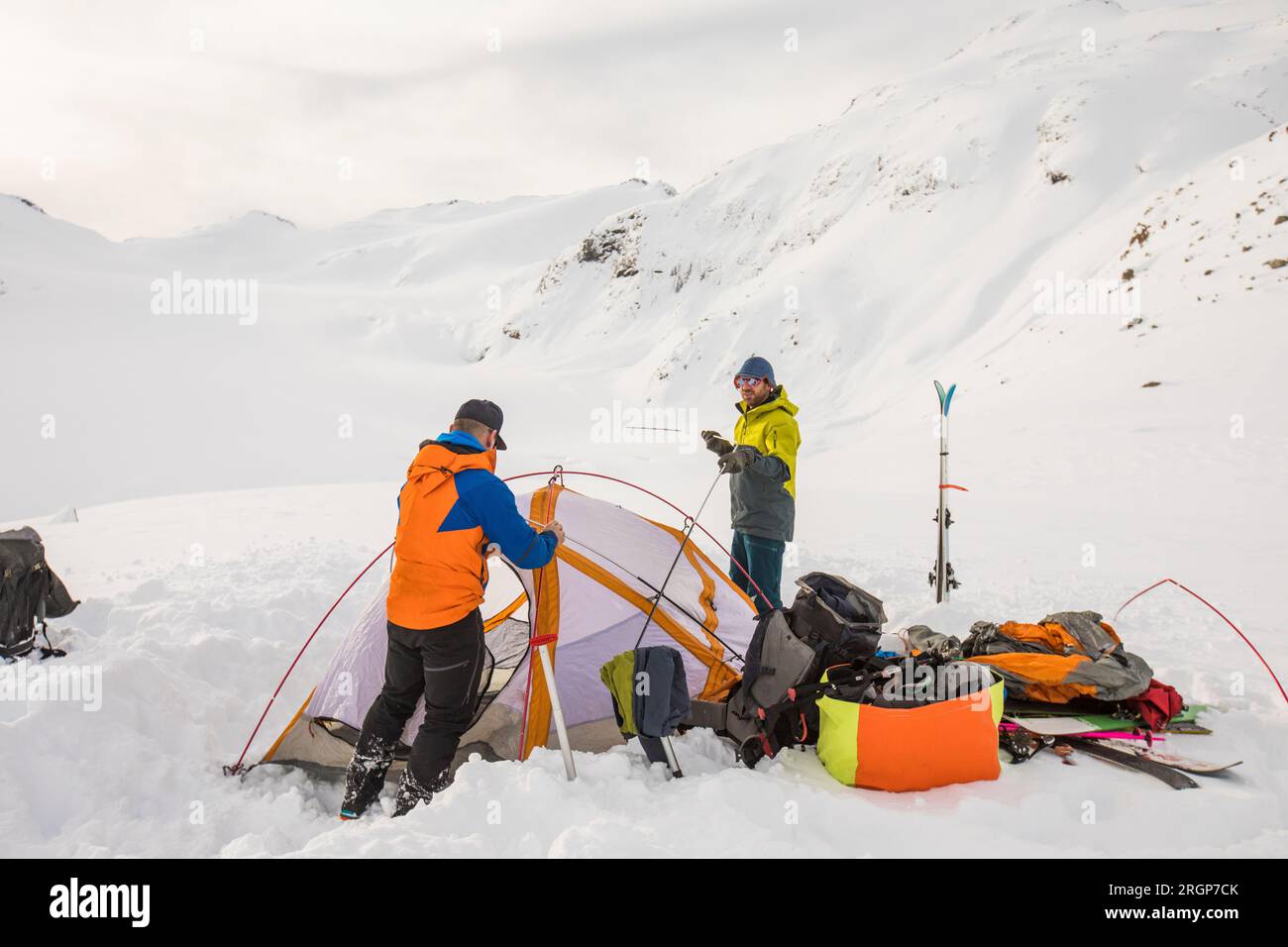 Deux hommes travaillent ensemble, mettant en place une tente de saison 4 sur le glacier Banque D'Images