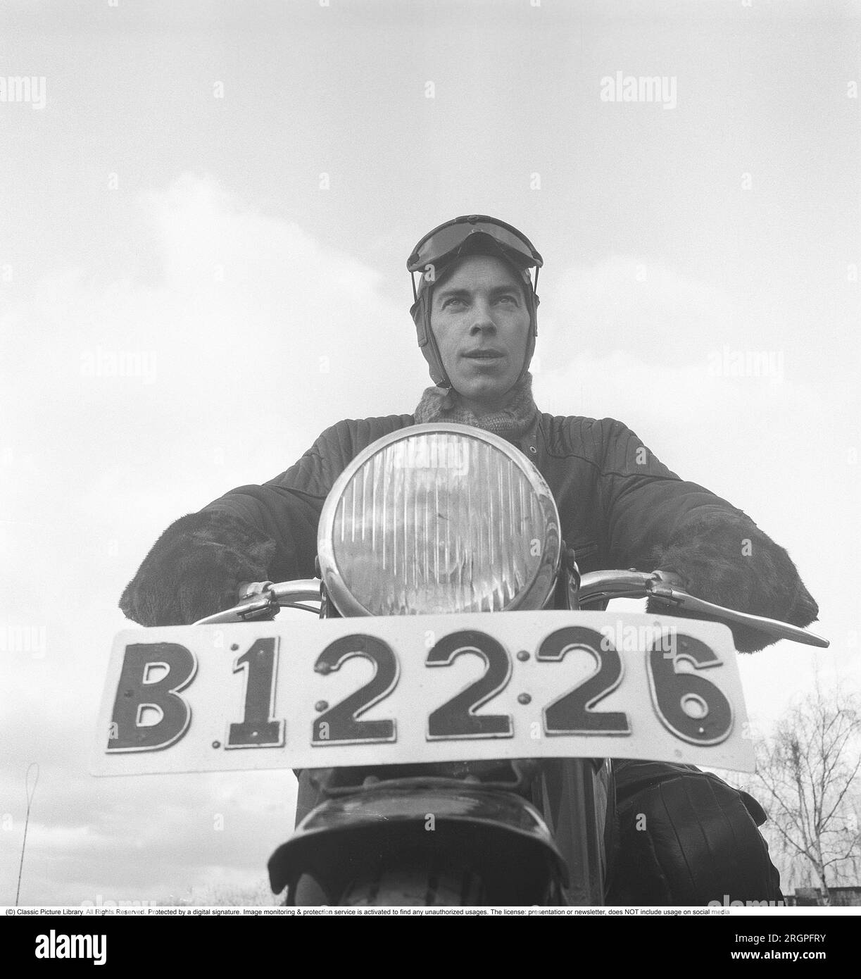Motocycliste dans les années 1950 Un jeune homme habillé de la manière typique des motocyclistes dans les années 1950 Tout en cuir. Bottes, pantalons et vestes en cuir. Il est assis sur sa moto. Suède 1953. Il est l'acteur Sven-Eric Gamble, 1924-1976. Kristoffersson réf. BM73-1 Banque D'Images