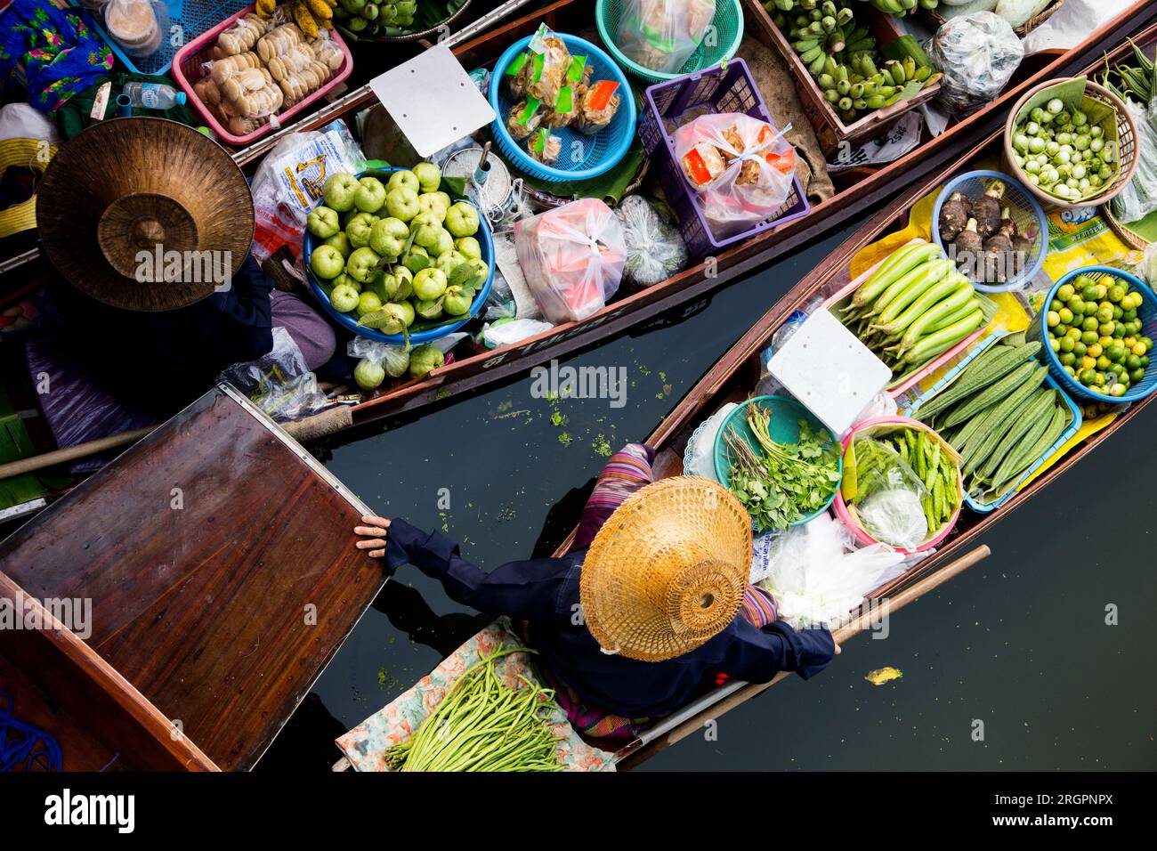 Les femmes vendent des légumes et des fruits de leurs canoës au marché flottant Tha Kha en Thaïlande. Banque D'Images