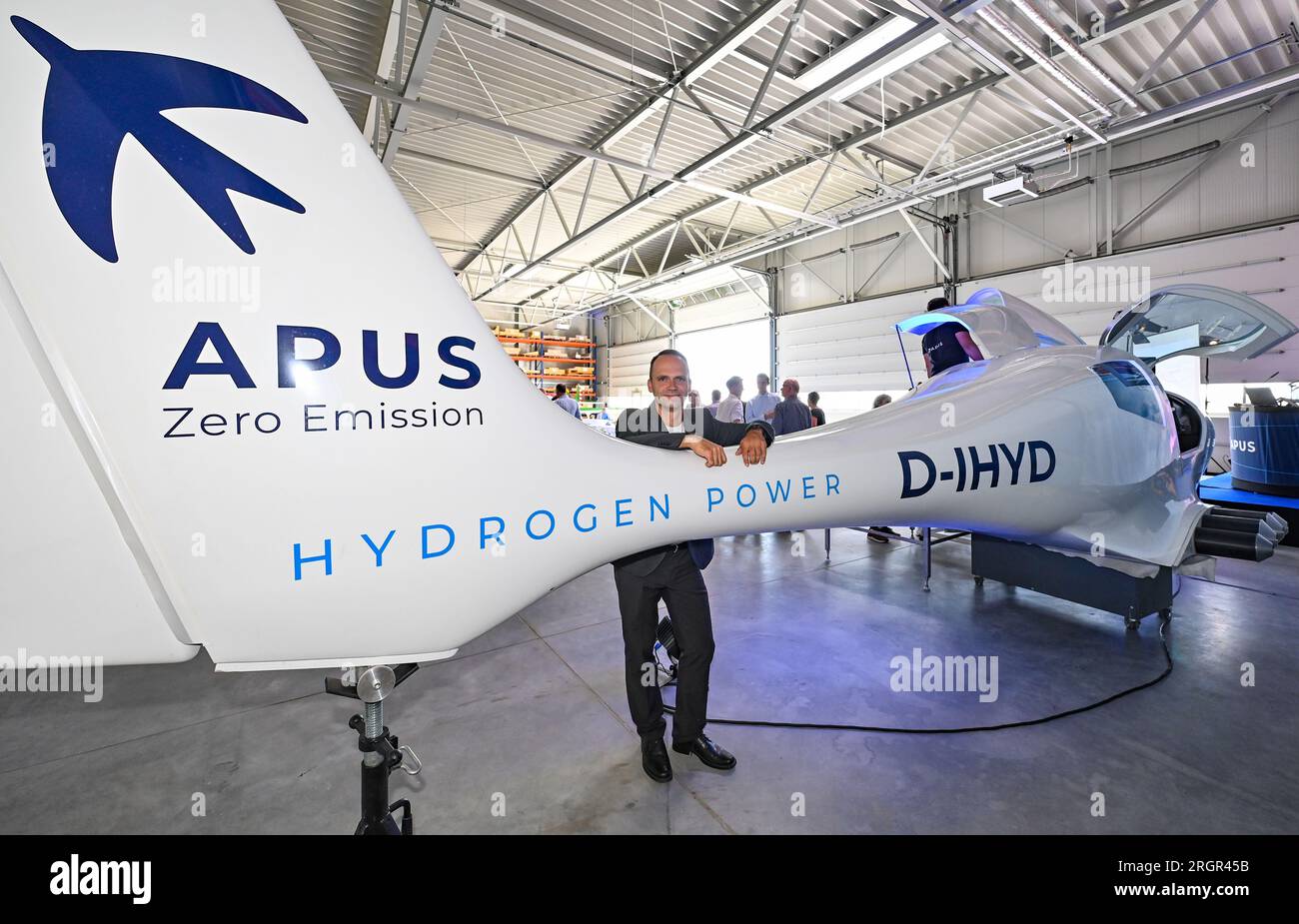 11 août 2023, Brandenburg, Strausberg : Phillip Scheffel, PDG d'APUS GmbH, se tient à côté d'un avion de démonstration APUS i-2 H2 Cell. APUS GmbH, leader dans le développement et la fabrication d’avions à hydrogène, a ouvert le même jour une usine d’essais et d’assemblage final à Strausberg. L'installation représente un investissement important pour l'avenir de l'aviation et aidera APUS à développer et à tester ses avions fonctionnant à l'hydrogène. Le centre d'essai du complexe est principalement utilisé pour les essais de propulsion. À cette fin, un banc d'essai a été construit pour tester la pile à combustible, les batteries et le système de propulsion électrique hybride. APUS était f Banque D'Images