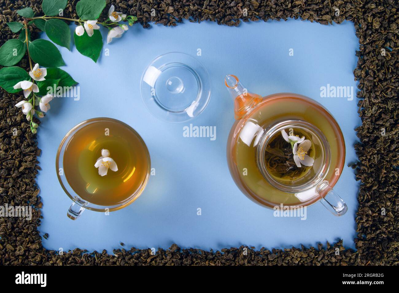 La maquette de cadre rectangulaire renferme un arrangement de feuilles de thé séchées et de fleurs de jasmin nouvellement fleuries. Le point focal comprend une tasse de thé et une théière, cent Banque D'Images