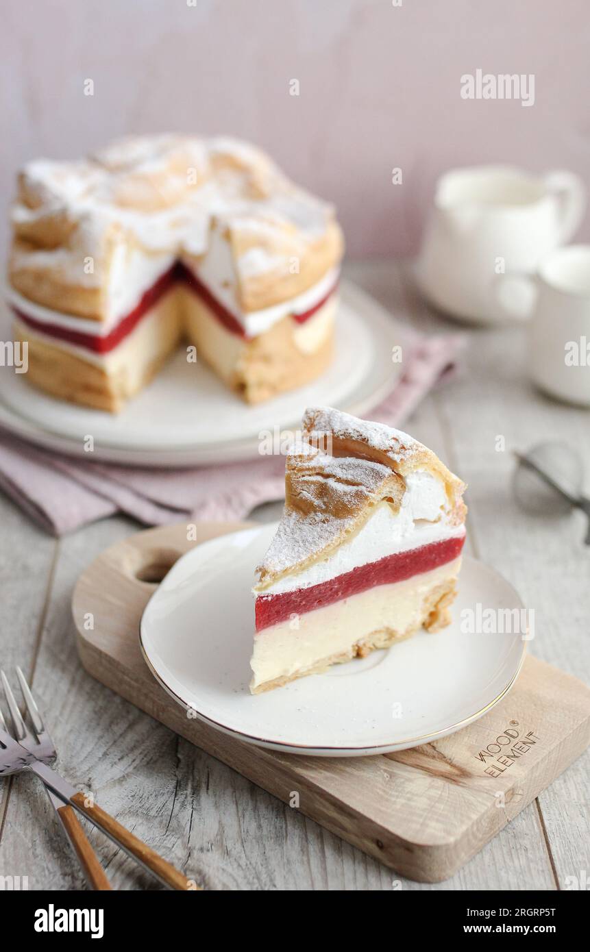 Gâteau polonais des Carpates Karpatka. Gâteau feuilleté à la crème avec fraises. Table en bois et fond rose. Banque D'Images