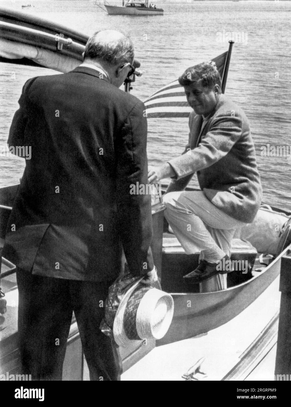 Hyannis Port, Massachusetts : 8 juillet 1961 le président Kennedy entre dans le cockpit du yacht, 'Marlinn', alors que le secrétaire d'État Dean Rusk marche à l'arrière. Banque D'Images