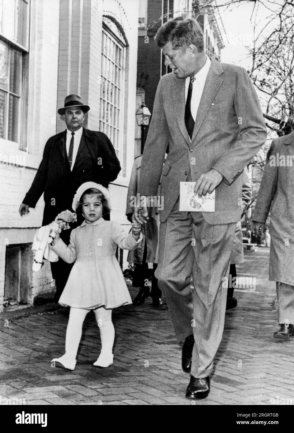 Washington, DC : 27 novembre 1960 le président élu Kennedy marche avec sa fille Caroline sur leur chemin pour les services religieux à son troisième anniversaire. Par la suite, Kennedy est allé à l'hôpital de Georgetown pour rendre visite à sa femme et à leur fils nouveau-né. Banque D'Images