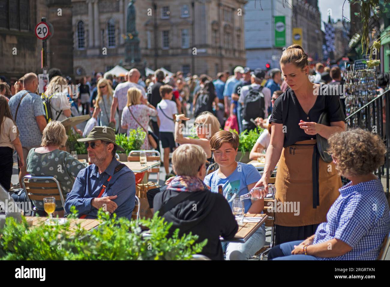 Royal Mile, Écosse, Royaume-Uni. 11 août 2023. Street Performers sur High Street trouver les conditions venteuses difficiles mais le temps chaud bienvenue avec une température un peu plus de 20 degrés. Les foules arrivent plus tard dans la journée avec plusieurs autres emplacements de spectacles autour du centre-ville. Sur la photo : les gens profitent d'un verre en plein air dans l'un des cafés de la High Stree. Crédit : Archwhite/alamy Live News. Banque D'Images