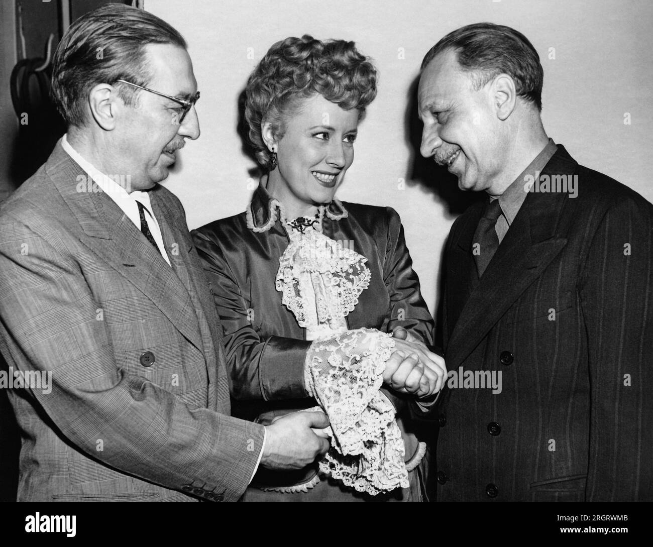 Hollywood, Californie : 6 mai 1946 l'actrice Irene Dunne félicite les auteurs Howard Lindsey (G) et Russel Crouse (D) pour avoir reçu le prix Pulitzer pour leur pièce, 'State of the Union'. Dunne joue dans le film, "Life with Father", basé sur la pièce des deux auteurs. Banque D'Images