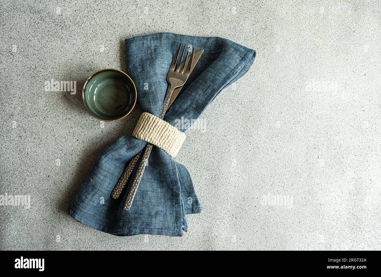 Table minimaliste avec serviette bleu profond et couverts modernes Banque D'Images