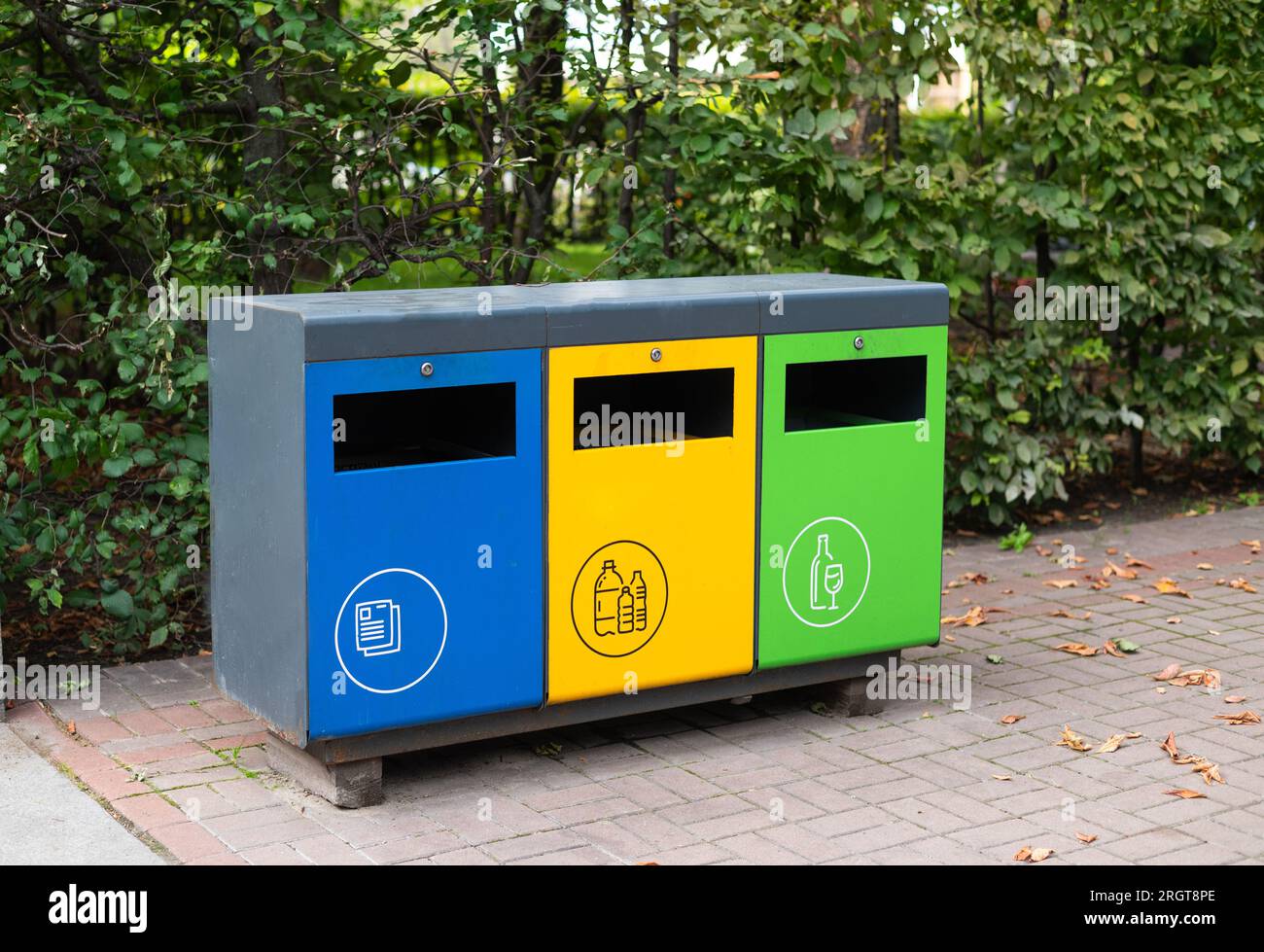 Trois conteneurs à ordures différents pour trier les déchets dans le parc. Jaune pour le plastique, vert pour le verre, bleu pour le papier. Séparation et tri des déchets, co Banque D'Images Trois conteneurs à ordures différents pour trier les déchets dans le parc. Jaune pour le plastique, vert pour le verre, bleu pour le papier. Séparation et tri des déchets, co Banque D'Images