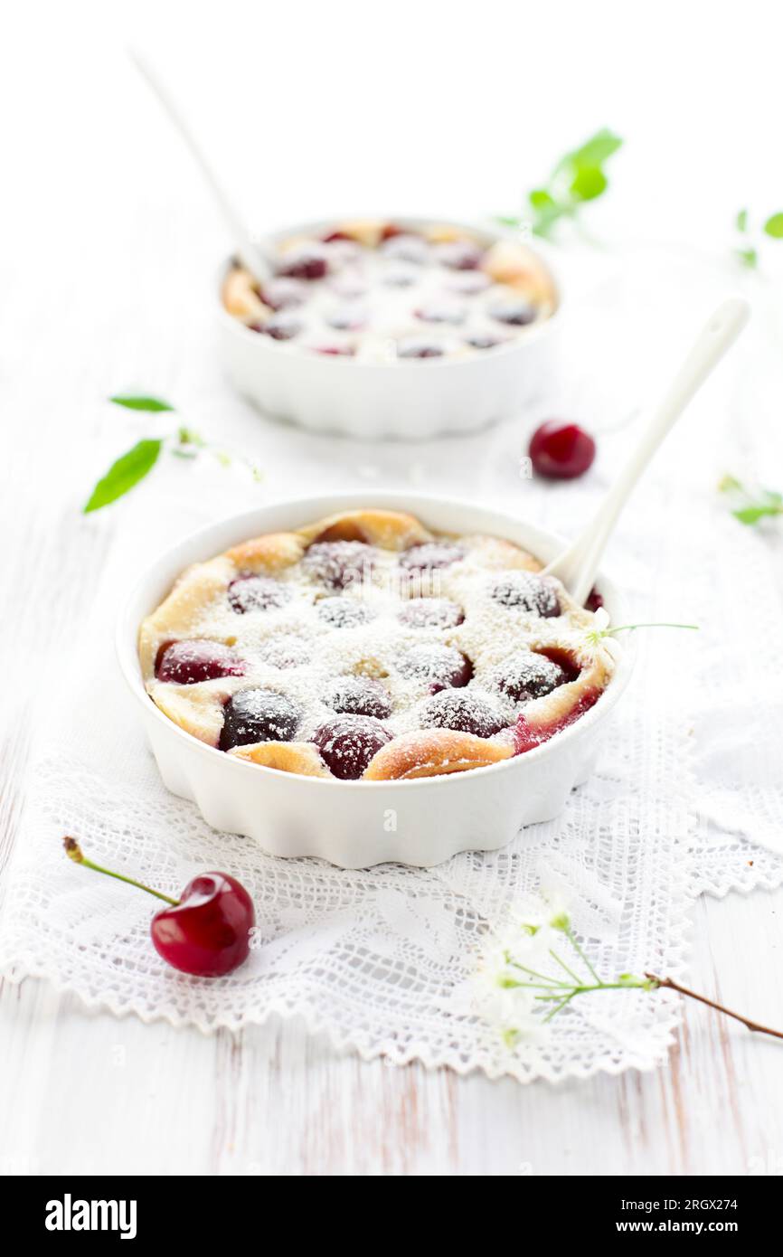 Cerise Clafoutis avec sucre en poudre dans des plats de cuisson Banque D'Images