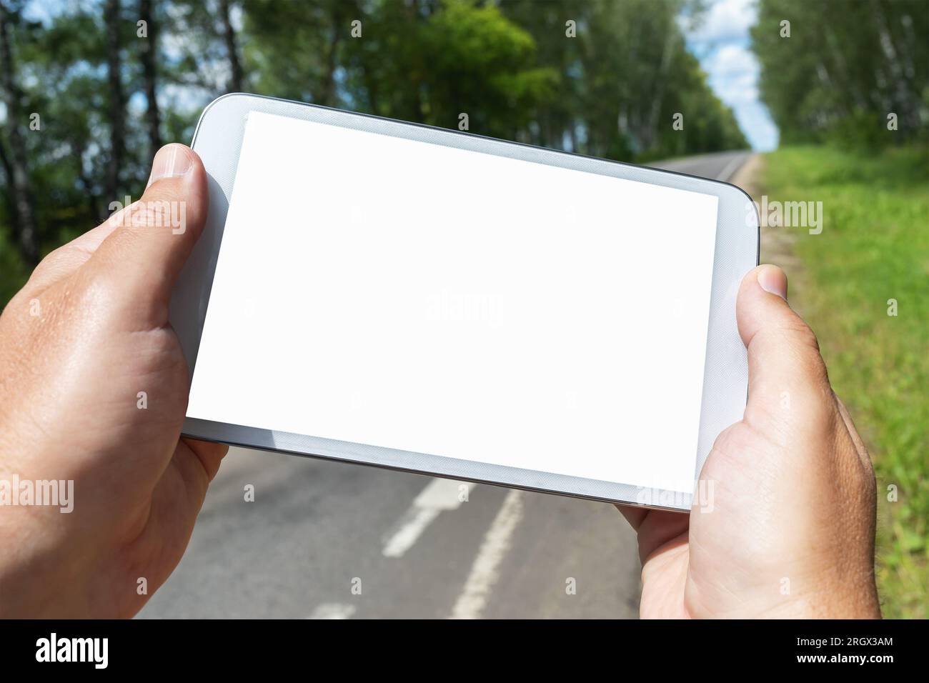 Un homme tient une tablette dans ses mains sur le fond de la route, un modèle pour le designer Banque D'Images