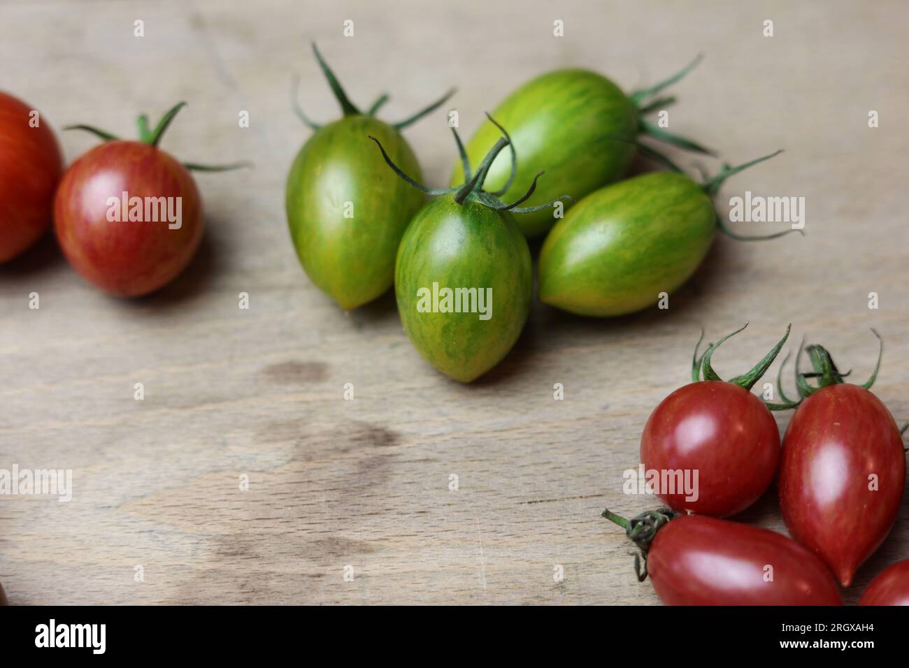 une variété de tomates fraîches multicolores sur une table en bois Banque D'Images