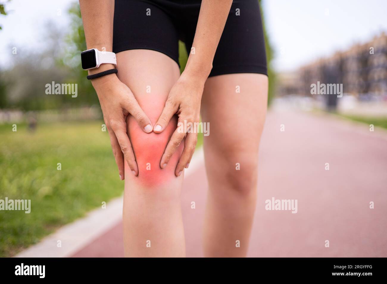 Blessure liée à l'entraînement sportif. Athlète féminine tenant le genou dans la douleur pendant l'entraînement de course à l'extérieur. Banque D'Images