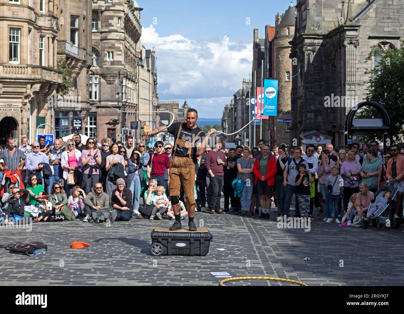 Royal Mile, Édimbourg, Écosse, Royaume-Uni. 12 août 2023. Edinburgh Festival Fringe, artistes de rue dans la High Street se produisant devant un grand public, venteux pour ceux qui sont sur les plates-formes, le soleil et parfois de fortes averses. Sur la photo Reidiculous craque ses fouets pour le public sur la High Street. Crédit : Archwhite/alamy Live News. Banque D'Images