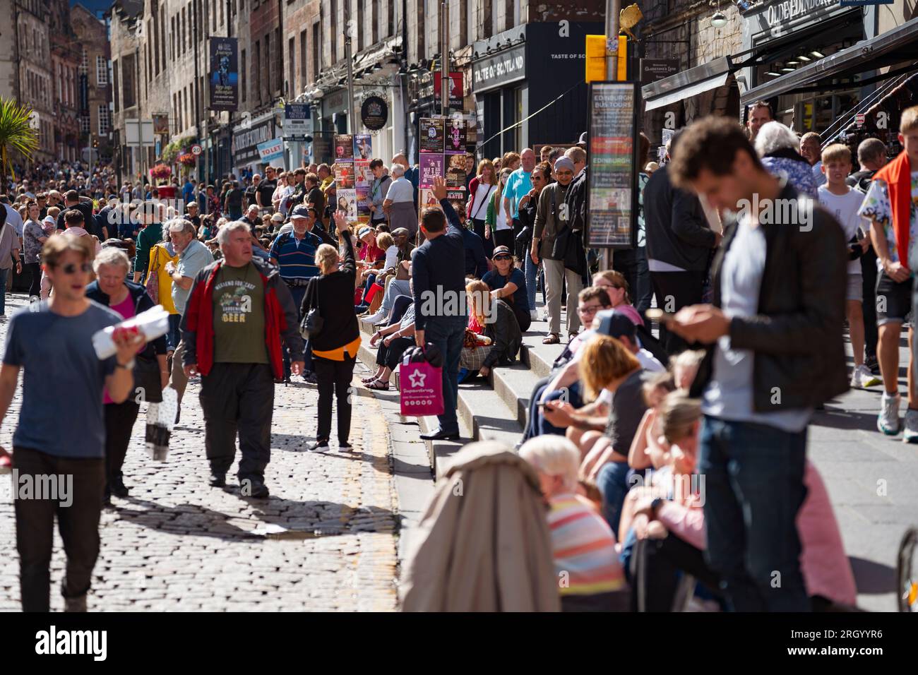 Édimbourg, Écosse, Royaume-Uni. 12 août 2023. Les températures chaudes et le soleil ont vu des milliers de visiteurs dans le centre-ville d'Édimbourg pendant les festivals International et Fringe. Le Royal Mile était extrêmement occupé alors que le public venait regarder des artistes de rue. Pic ; les rues étaient remplies de touristes et d'habitants comme ici à Lawnmarket sur le Royal Mile. Iain Masterton/Alamy Live News Banque D'Images