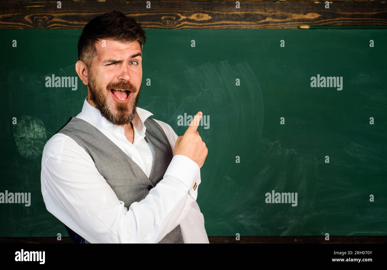 Retour à l'école. Professeur heureux près du tableau pointant vers l'espace de copie. Étudiant souriant à l'université. Éducation, apprentissage, enseignement. Professeur d'université à Banque D'Images