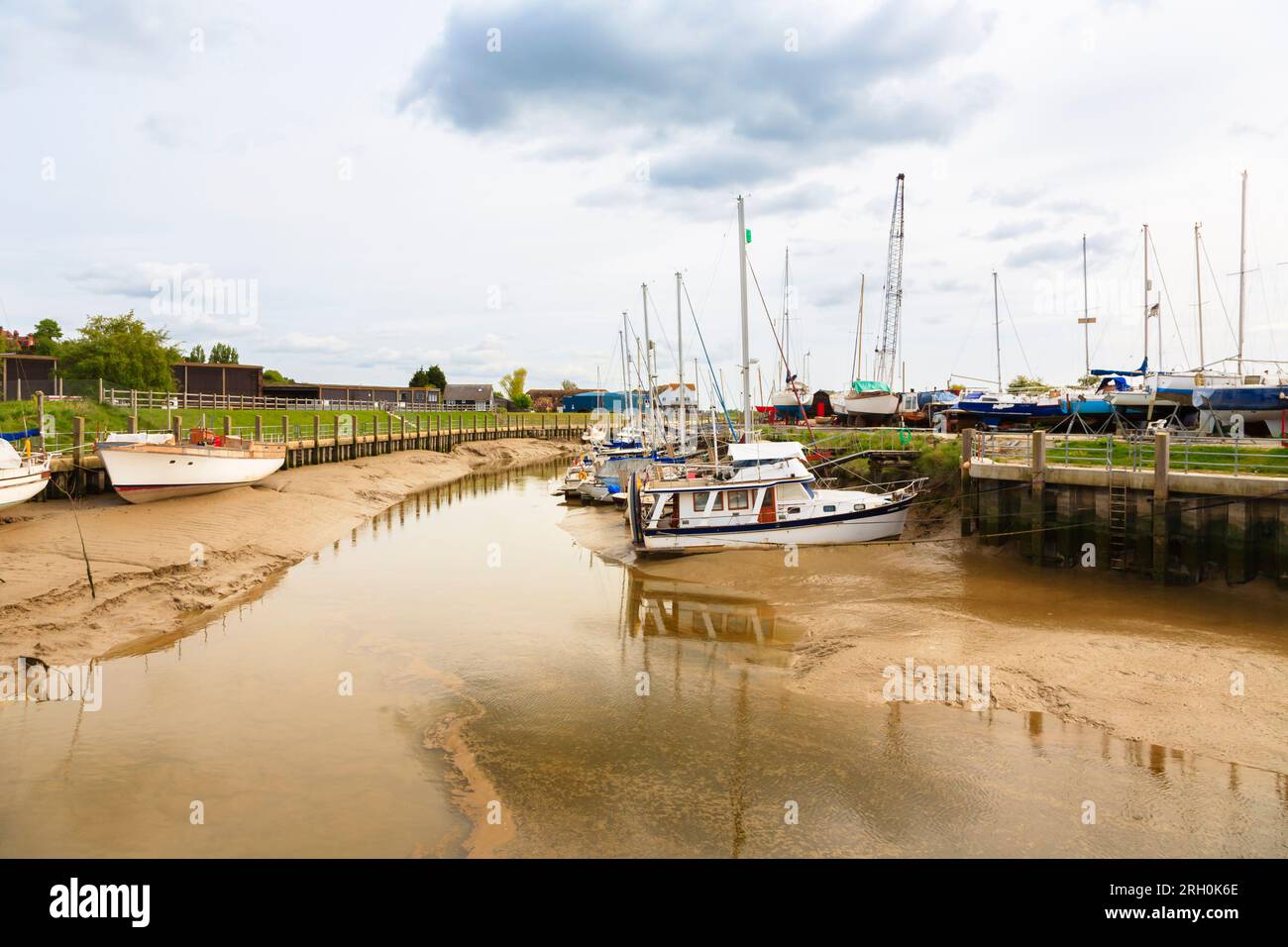 Bateaux amarrés reposant sur les rives boueuses à marée basse sur la rivière Rother à Rye Harbour, un petit village côtier près de la ville de Rye dans l'East Sussex Banque D'Images