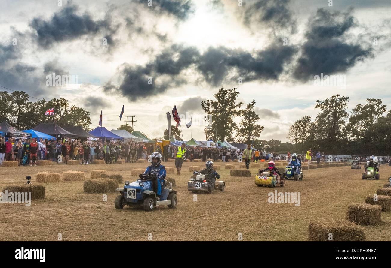 Les pilotes de tondeuse à gazon de course accélèrent le long de la BLMRA 500, une course de tondeuse à gazon de nuit de 800 km (500 miles) dans le style du Mans dans un champ du West Sussex, au Royaume-Uni. La British Lawn Mower Racing Association organise son 50e anniversaire de course de 12 heures dans la nuit samedi/dimanche avec 52 équipes, chacune avec trois pilotes. Banque D'Images