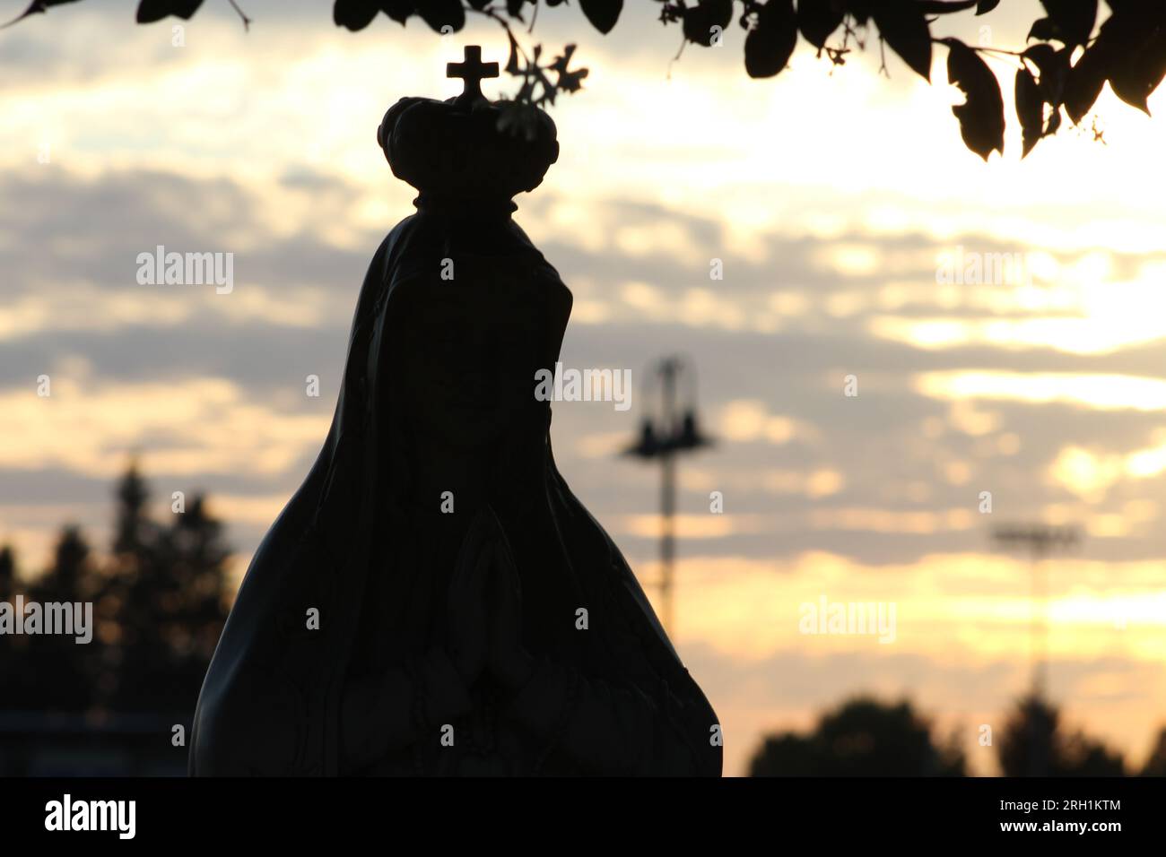 'Dans l'étreinte douce d'un coucher de soleil doré, son cœur et son âme s'unissent dans la prière, un moment de connexion sacrée.' Banque D'Images