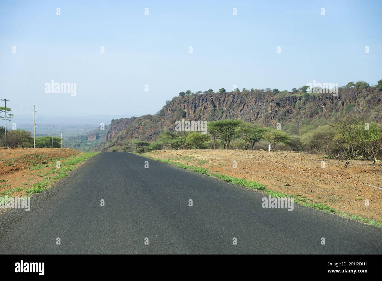 Vue de la route Nakuru-Sigor avec arbres et escarpement rocheux, Kenya Banque D'Images