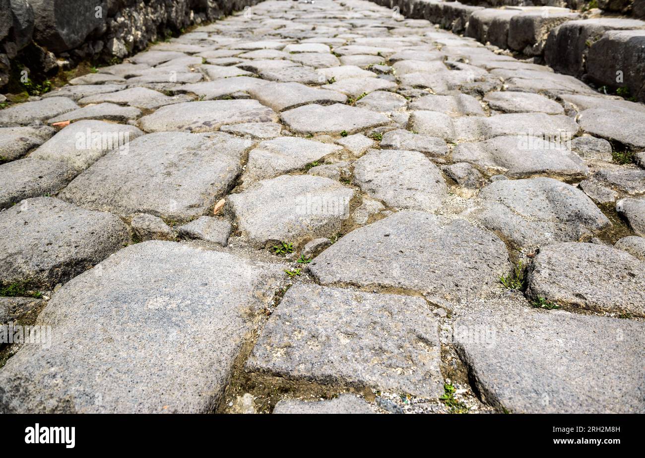 Ancienne route pavée à Pompéi, Italie. Gros plan de texture de pavés de granit gris pour l'arrière-plan. Rochers de l'ancienne voie romaine. Thème de chaussée, antique Banque D'Images