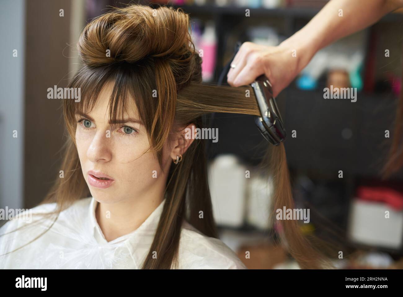 Défrisage des cheveux avec de la kératine et un fer à repasser Banque D'Images