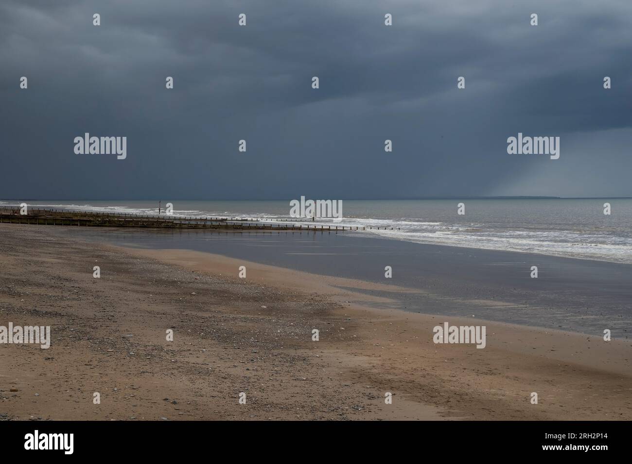 Ramasser sombre du nord sur la côte de Hornsea plage à la fin de l'été Banque D'Images