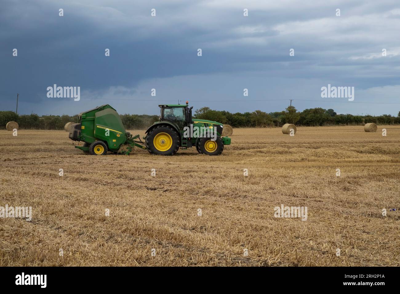 Tracteur John Deere et presse à balles à chambre V461M récoltant le foin pour le fourrage d'hiver fin juillet sur la ferme Eastern Yorkshire , Royaume-Uni Banque D'Images