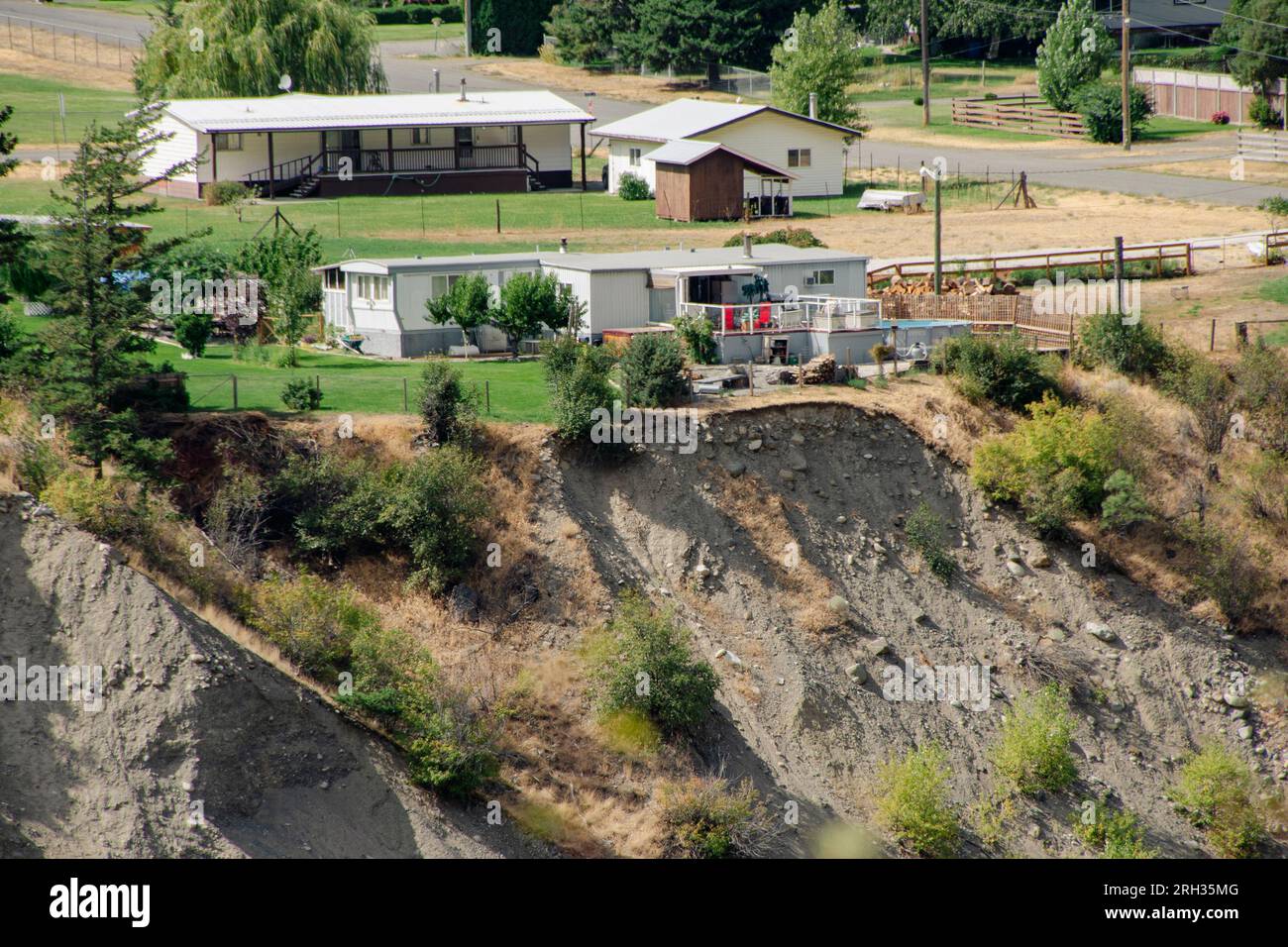 Une maison tétonne sur le bord d'une rivière qui est lentement erré loin en Colombie-Britannique Canada Banque D'Images