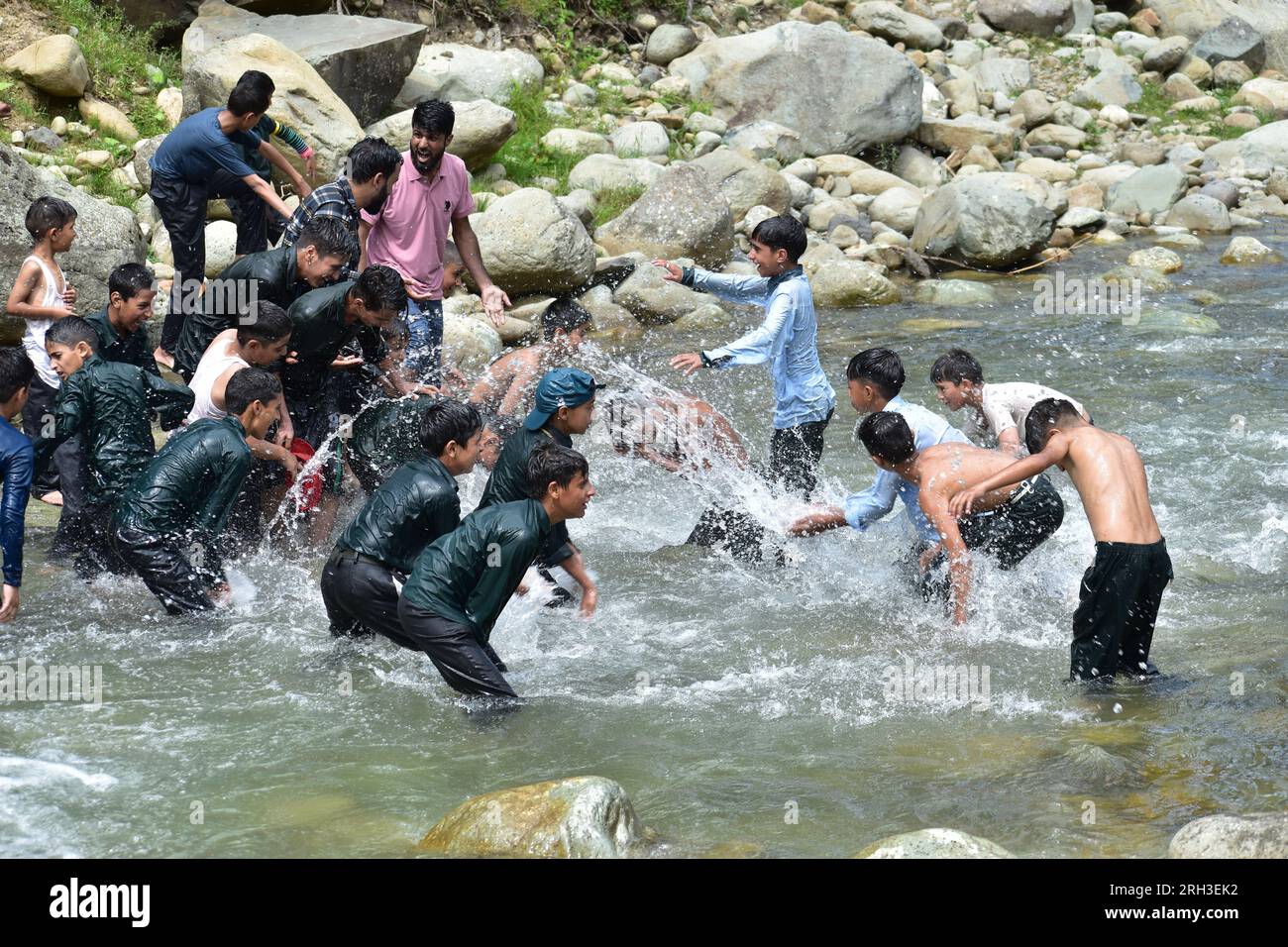 Doodhganga Yousmarg, Cachemire. Le 13 août, les étudiants cachemiriens trouvent un répit de la chaleur alors qu’ils se rafraîchissent dans les eaux rafraîchissantes de Doodhganga Yousmarg, transformant une journée étouffante en une escapade mémorable. Photos par crédit : Danish Showkat/Alamy Live News Banque D'Images