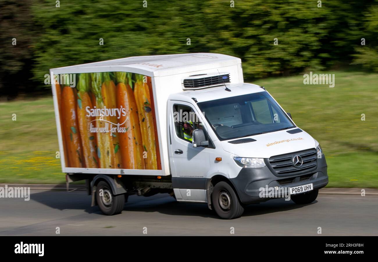 Milton Keynes, Royaume-Uni - 11 août 2023 : Mercedes Benz Sprinter utilisé comme camion de livraison Sainsbury. Conduite sur une route de campagne anglaise. Banque D'Images