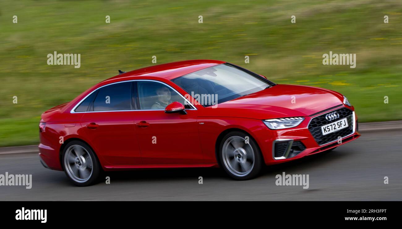 Milton Keynes, Royaume-Uni - 11 août 2023 : Red 2023 Audi A4 berline conduisant sur une route de campagne anglaise. Banque D'Images