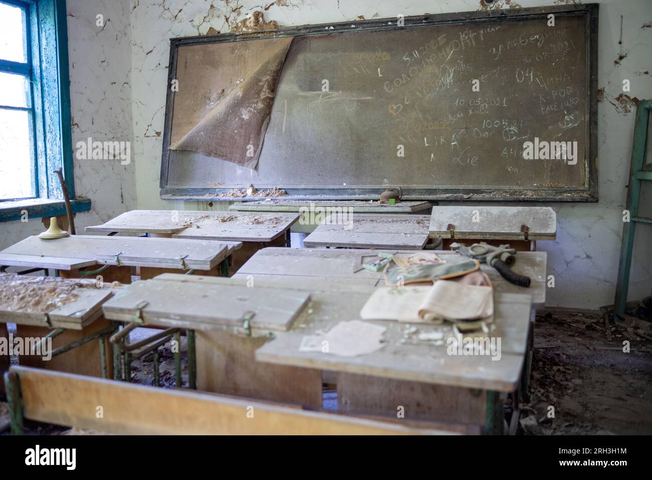 Salle de classe dans une école abandonnée avec des carnets sur des bureaux dans la zone d'exclusion du Bélarus Banque D'Images